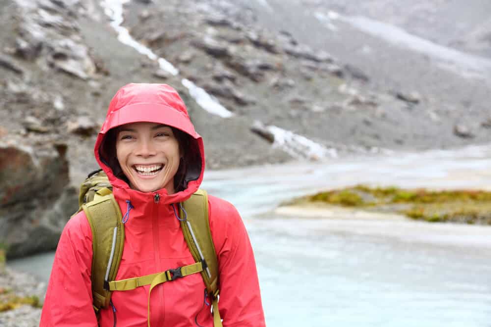 Smiling woman in rain jacket during her Iceland camping trip in September