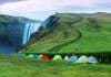 Multiple tents set up at Skógafoss waterfall for camping in Iceland in September