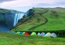 Multiple tents set up at Skógafoss waterfall for camping in Iceland in September