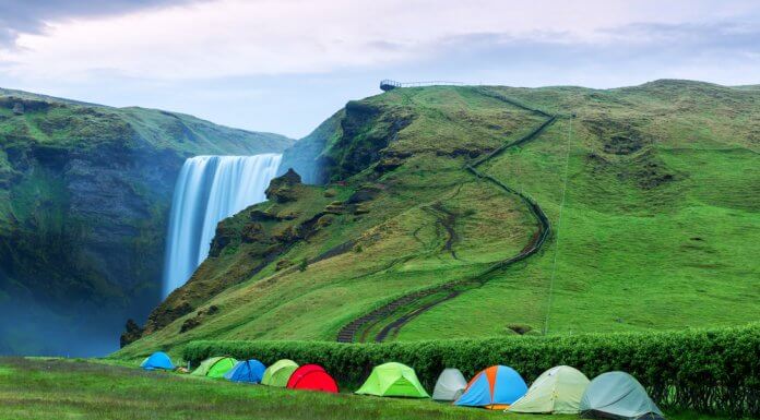 Multiple tents set up at Skógafoss waterfall for camping in Iceland in September