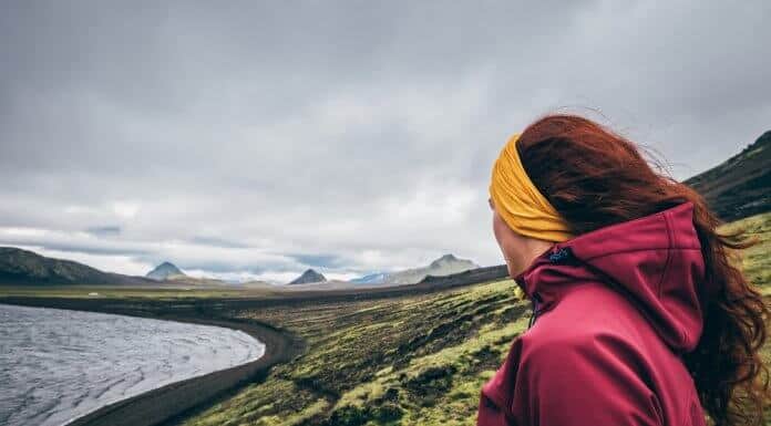 Female tourist looking at the mossy landscape while camping in Iceland