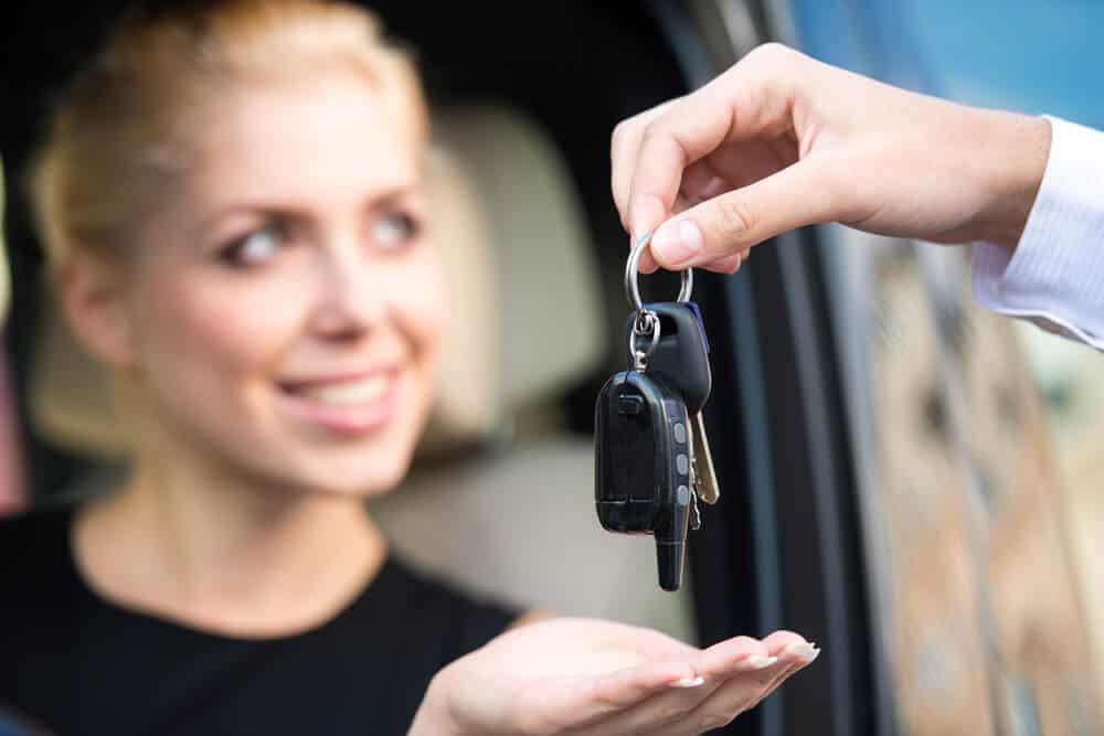 Woman receiving the keys to her Iceland car rental