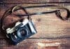 Retro camera on vintage wooden background showing best photography in Iceland concept