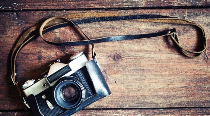Retro camera on vintage wooden background showing best photography in Iceland concept