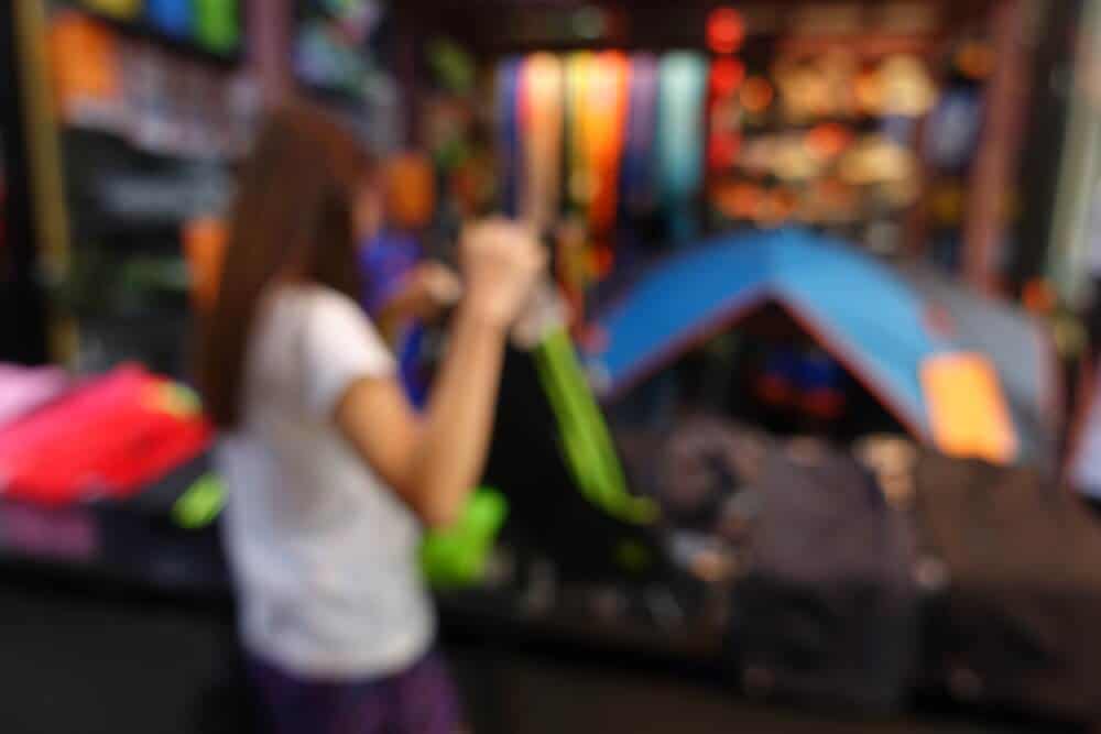 Woman choosing gear at camping equipment rental store in Iceland