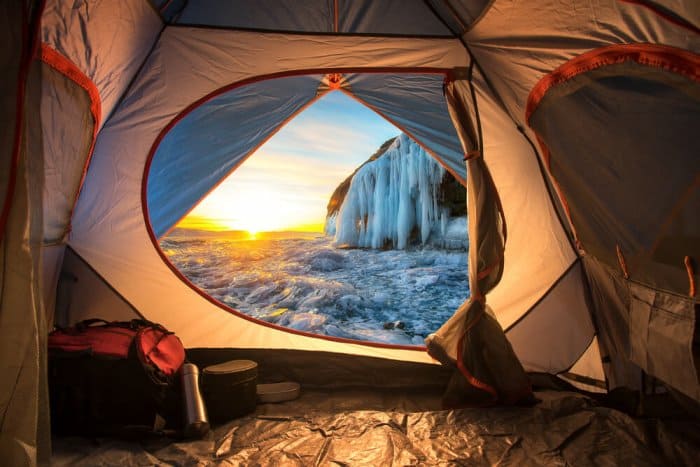 View of frozen waterfall from tent during Iceland camping trip