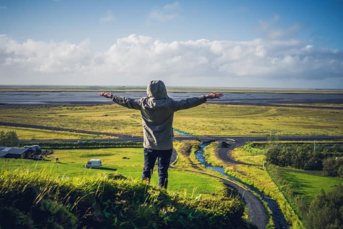 Nice Iceland Weather in August and a man enjoying the viws from a cliff