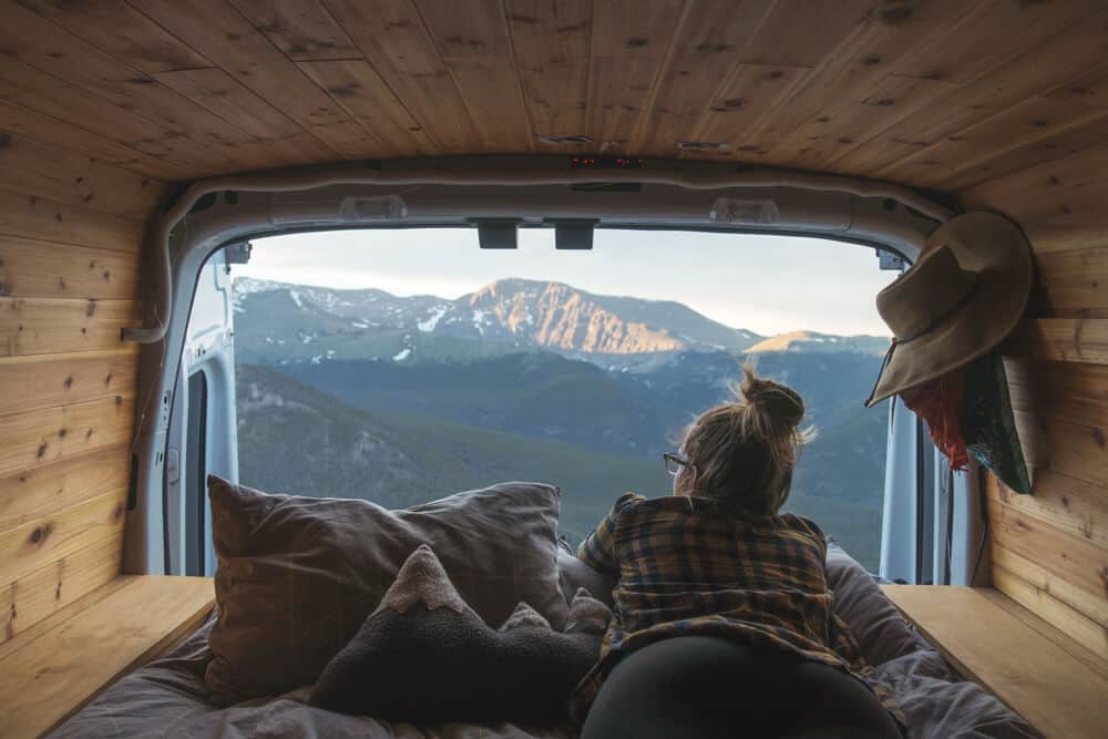 Woman looking out at mountains from campervan during Iceland road trip