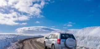 Car driving on icy, ashy, sandy roads in Iceland