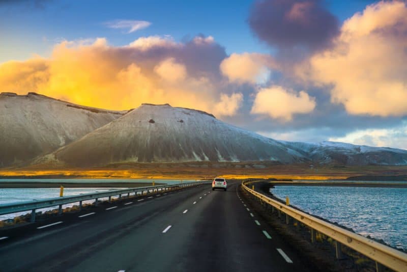 Driving down the road in Iceland with snowy winter mountains in the background