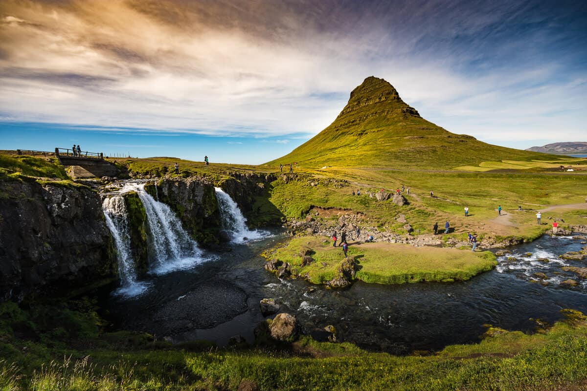 People hiking at Kirkjufell's base. Climbing the peak is not recommended. 