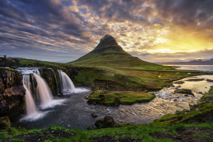 Snaefellsnes peninsula with Kirkjufell mountain and Kirkjufellsfoss waterfall illuminated sky