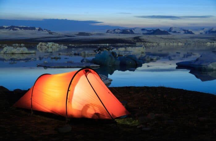 Red tent over Jokulsarlon lagoon, Iceland at dusk while camping in Iceland in November