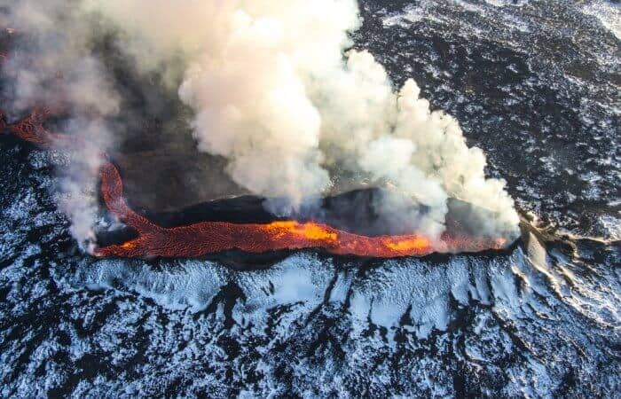 Volcano in Iceland producing smoke and hot melted lava
