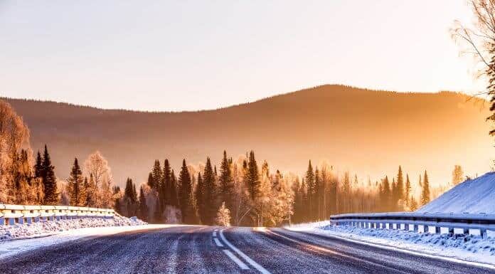 Icy winter road with mountains in background