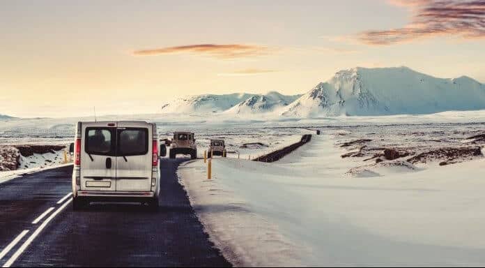 Campervan on the ring road with snow on the shoulder and a pink sky